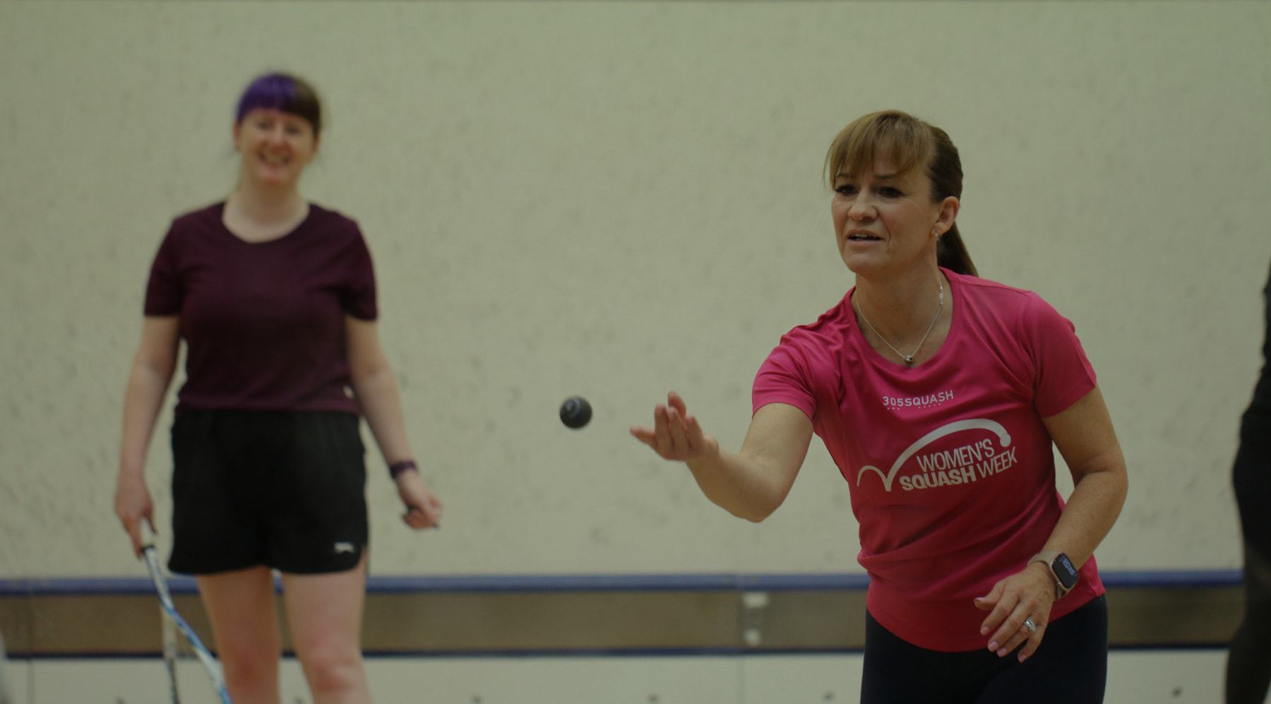 Female squash coach and player during a coaching session on court