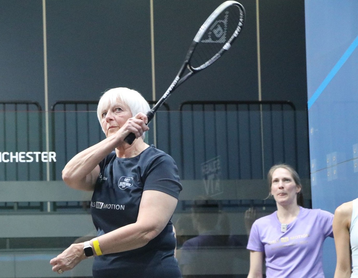 A female squash coach giving an individual coaching session to a woman player on a UK squash court