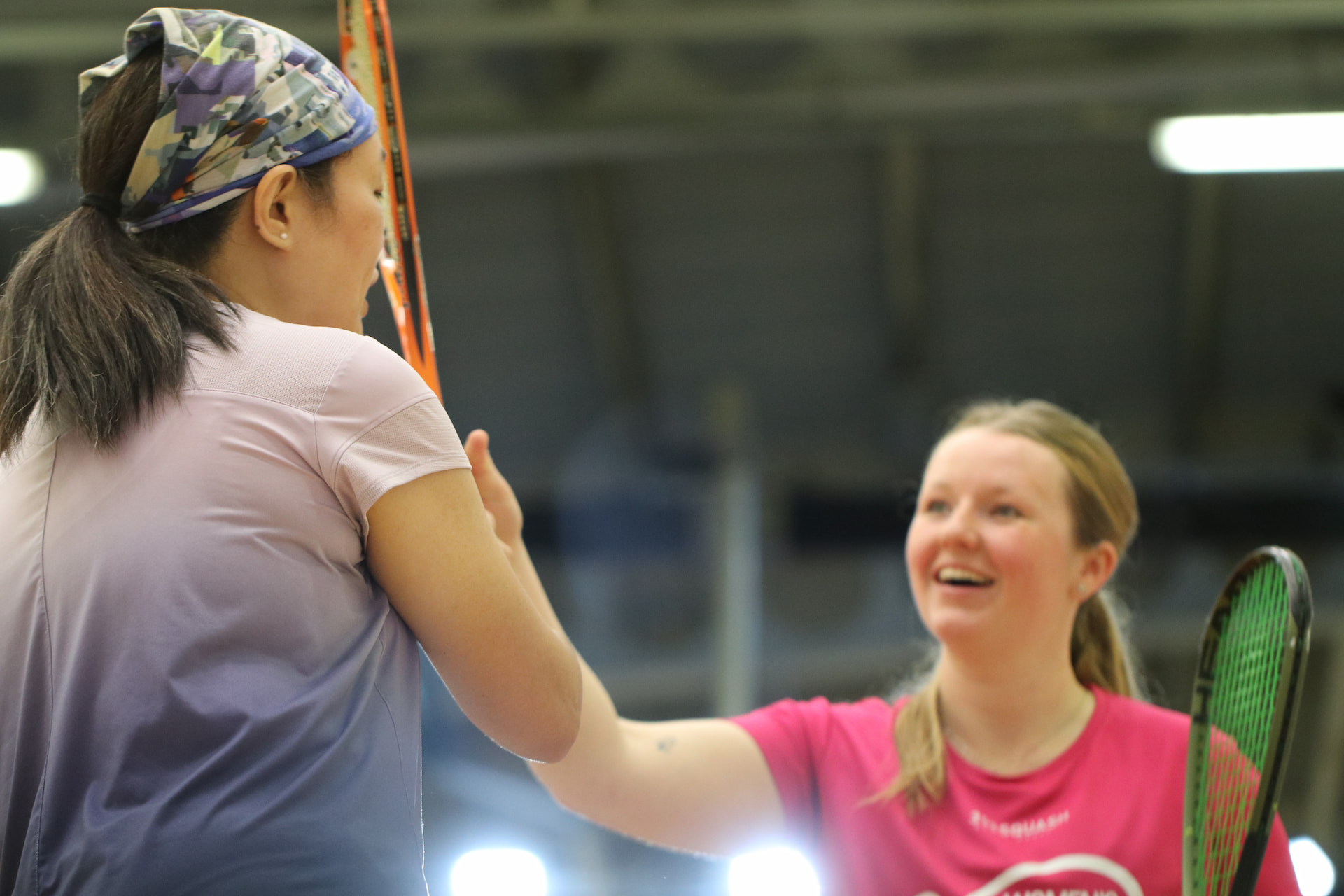 Player and coach smiling after a one-to-one squash coaching session