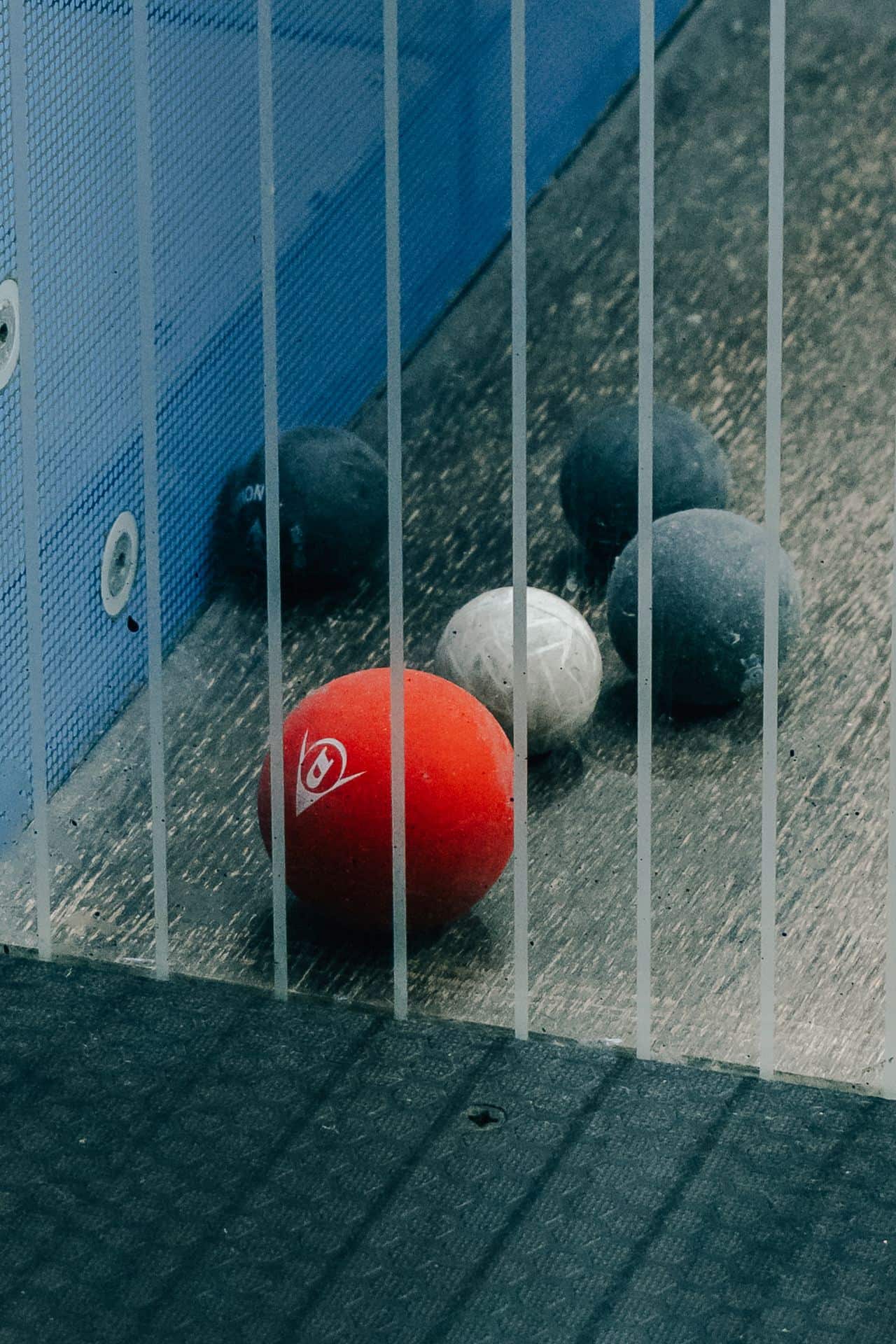 A squash racket and balls on a court — equipment used in junior coaching sessions
